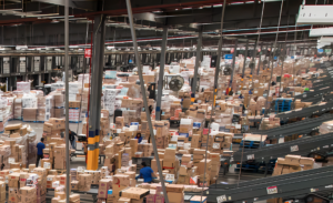 Centro logístico con cajas, transportadores y personal operativo en un almacén automatizado. La infraestructura refleja procesos de inteligencia artificial, gestión de inventarios y optimización de la cadena de suministro de Walmart. Walmart y la inteligencia artificial: cómo usa IA para impulsar crecimiento