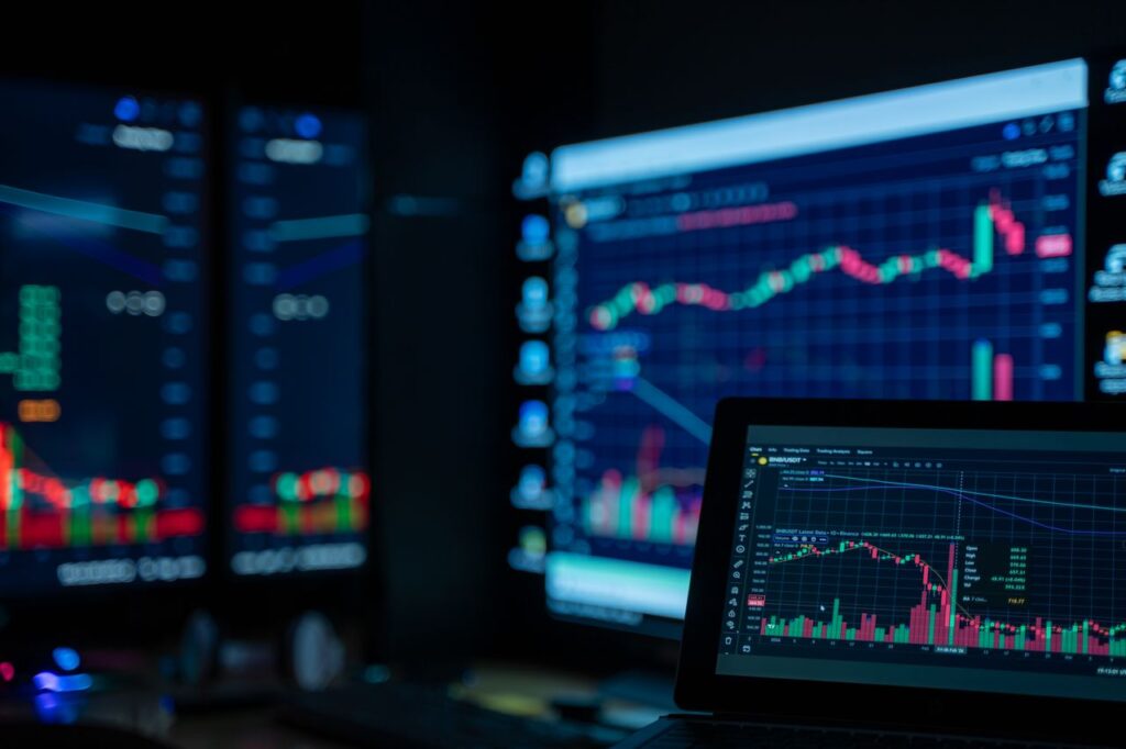 Monitores muestran gráficos financieros y una plataforma de trading utilizada para analizar mercados y operar con una cuenta financiada. Mejor cuenta financiada de trading en México 2026: cómo elegir la plataforma correcta y qué implica fiscalmente.