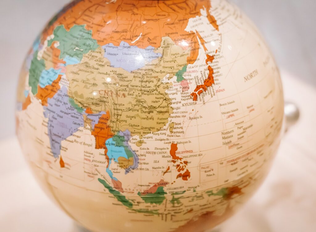 A close-up of a globe focused on the East Asia region, highlighting the coastal countries, archipelagos, and landmasses of this dynamic trade zone.